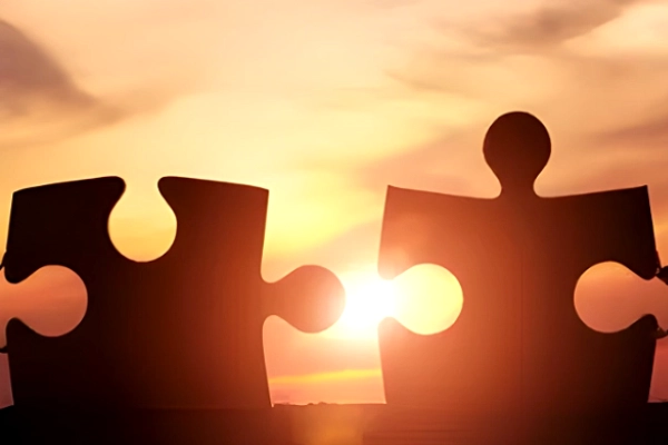 Two puzzle pieces fit together, representing partnerships that strengthen local communities.
